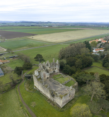 Aerial view of Dirleton Castle and Gardens featuring historic stone ruins and lush green lawns in Dirleton Scotland United Kingdom. Aerial view of Dirleton Castle and Gardens featuring historic stone ruins and lush green lawns in Dirleton Scotland United Kingdom.