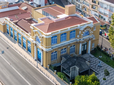 Cruz Quebrada Portugal 25 July 2026 Aerial view of Vasco da Gama Aquarium a historic yellow building with terracotta roof tiles and blue azulejo accents near a road.