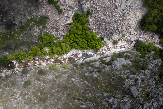 Aerial view of a narrow stream flowing through a rocky canyon with lush green vegetation and steep stone slopes Cape Town Western Cape South Africa. Aerial view of a narrow stream flowing through a rocky canyon with lush green vegetation and steep stone slopes Cape Town Western Cape South Africa.
