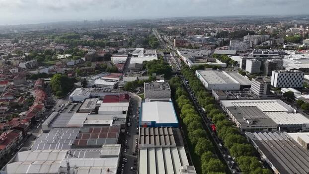 Aerial view of industrial zone with a lot of warehouses and tree lined road Portugal.