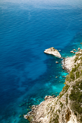 Aerial view of the rugged coastline with turquoise waters rocky cliffs and lush green vegetation in Corfu Ionian Islands Greece. Aerial view of the rugged coastline with turquoise waters rocky cliffs and lush green vegetation in Corfu Ionian Islands Greece.