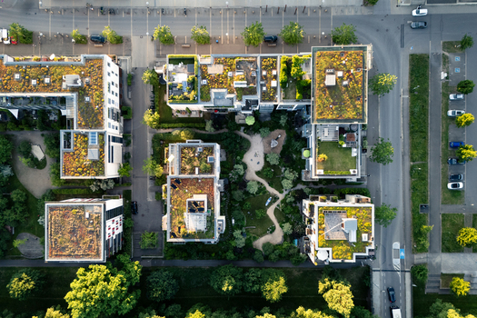 Aerial view of modern residential buildings featuring sustainable green roofs and a lush inner courtyard with winding paths in Tubingen Baden Wurttemberg Germany. Aerial view of modern residential buildings featuring sustainable green roofs and a lush inner courtyard with winding paths in Tubingen Baden Wurttemberg Germany.