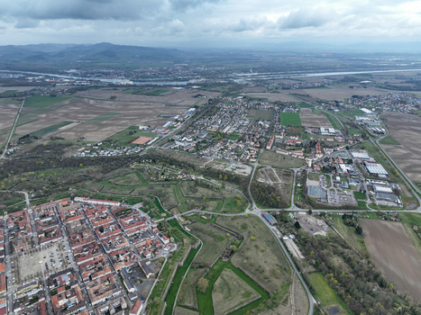Aerial view of the star shaped fortress city its red roofed buildings contrasting with the green fields and distant mountains Neuf Brisach Grand Est France.