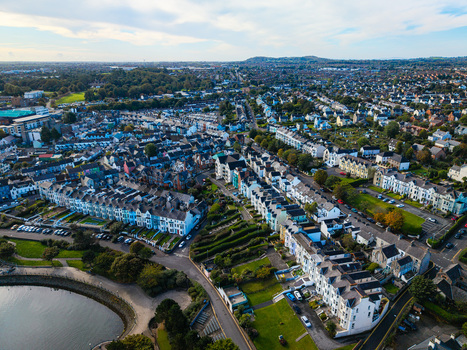 Aerial view of Bangor Harbour and Town featuring rows of historic terraced houses lush green spaces and the coastal waterfront in Bangor Northern Ireland United Kingdom.