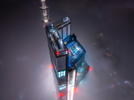 Aerial view of the illuminated top of Varso Tower skyscraper in Warsaw emerging from thick night fog with an observation deck and antenna in Poland. Aerial view of the illuminated top of Varso Tower skyscraper in Warsaw emerging from thick night fog with an observation deck and antenna in Poland.