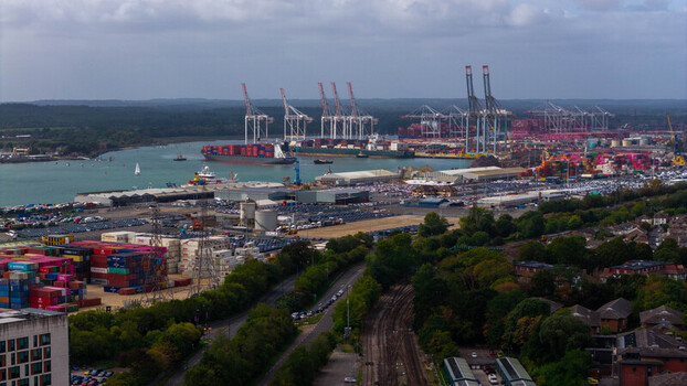 Aerial view of the busy Port of Southampton with large container ships numerous cranes rows of shipping containers and industrial infrastructure in Southampton England United Kingdom. Aerial view of the busy Port of Southampton with large container ships numerous cranes rows of shipping containers and industrial infrastructure in Southampton England United Kingdom.