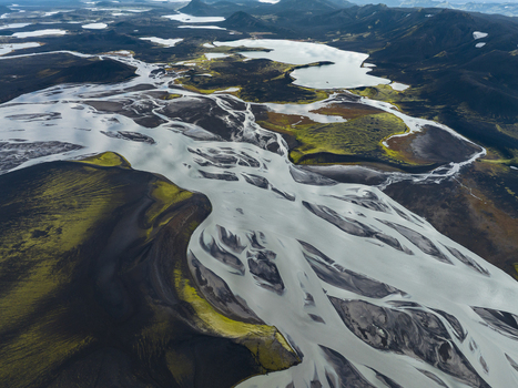 Aerial view of glacial rivers carve through volcanic sands creating a stark contrast of textures and tones in the highlands Highlands Iceland.
