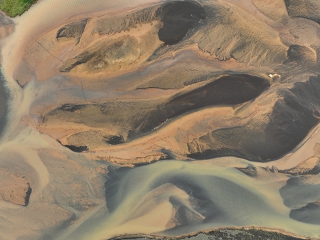 Aerial view of the braided river delta in Iceland showcasing intricate patterns of sediment glacial water and dark volcanic sand in Selfoss Sveitarfelagid Arborg Iceland. Aerial view of the braided river delta in Iceland showcasing intricate patterns of sediment glacial water and dark volcanic sand in Selfoss Sveitarfelagid Arborg Iceland.