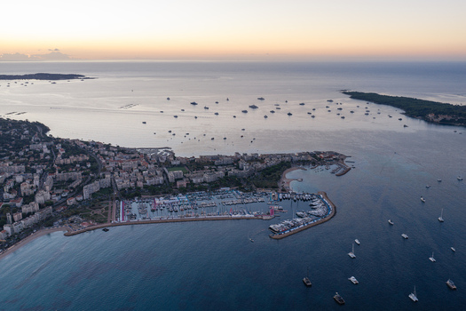 Aerial view of the harbor in Cannes with yachts moored in the marina surrounded by coastal architecture and the Mediterranean Sea at sunset Cannes Provence Alpes Cote d Azur France. Aerial view of the harbor in Cannes with yachts moored in the marina surrounded by coastal architecture and the Mediterranean Sea at sunset Cannes Provence Alpes Cote d Azur France.