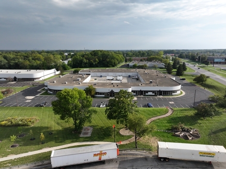 Aerial view of a commercial office building complex with a large parking lot green lawns and semi trailers in the foreground in Indianapolis Indiana United States. Aerial view of a commercial office building complex with a large parking lot green lawns and semi trailers in the foreground in Indianapolis Indiana United States.