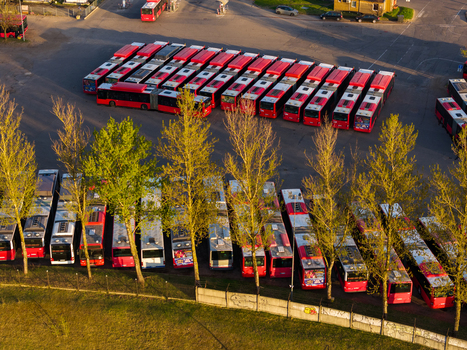 Vilnius County Lithuania 01 May 2026 Aerial view of rows of red and white public transport buses parked in a depot during golden hour. Vilnius County Lithuania 01 May 2026 Aerial view of rows of red and white public transport buses parked in a depot during golden hour.