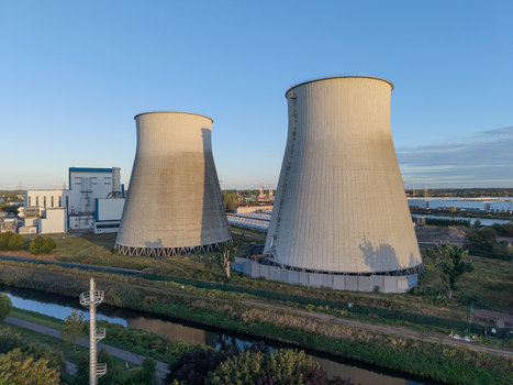 Aerial view of the cooling towers at the former power plant site now repurposed as a large scale battery energy storage system situated near a canal in Vilvoorde Flanders Belgium. Aerial view of the cooling towers at the former power plant site now repurposed as a large scale battery energy storage system situated near a canal in Vilvoorde Flanders Belgium.