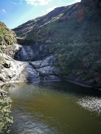 View of a waterfall cascading down rugged sandstone cliffs into a calm pool within the Golden Gate Highlands National Park Clarens Free State South Africa. View of a waterfall cascading down rugged sandstone cliffs into a calm pool within the Golden Gate Highlands National Park Clarens Free State South Africa.