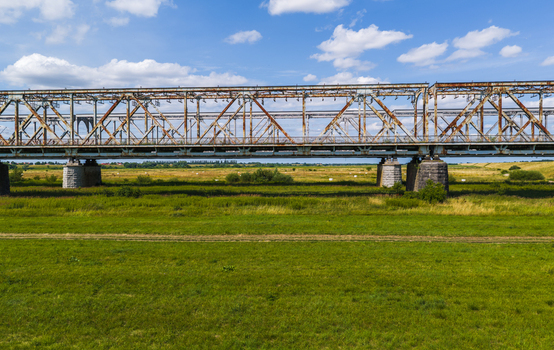 Aerial view of the historic Tczew Bridge with its metal truss structure spanning the green meadows of the Vistula River valley in Tczew Pomeranian Voivodeship Poland. Aerial view of the historic Tczew Bridge with its metal truss structure spanning the green meadows of the Vistula River valley in Tczew Pomeranian Voivodeship Poland.