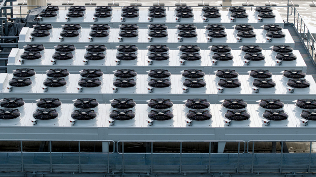 Aerial view of an industrial data center cooling system featuring rows of large fans on a rooftop in Krakow Lesser Poland Voivode Poland. Aerial view of an industrial data center cooling system featuring rows of large fans on a rooftop in Krakow Lesser Poland Voivode Poland.