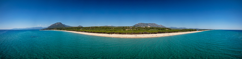 Aerial view of Spiaggia Osalla di Orosei with turquoise waters golden sand and a lush pine forest under a clear blue sky in Orosei Sardegna Italy. Aerial view of Spiaggia Osalla di Orosei with turquoise waters golden sand and a lush pine forest under a clear blue sky in Orosei Sardegna Italy.