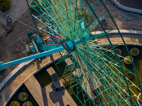 Aerial view of the iconic Ferris wheel at Spreepark showcasing its intricate metal structure wooden pathways and landscaped grounds during the golden hour in Berlin Berlin Germany. Aerial view of the iconic Ferris wheel at Spreepark showcasing its intricate metal structure wooden pathways and landscaped grounds during the golden hour in Berlin Berlin Germany.