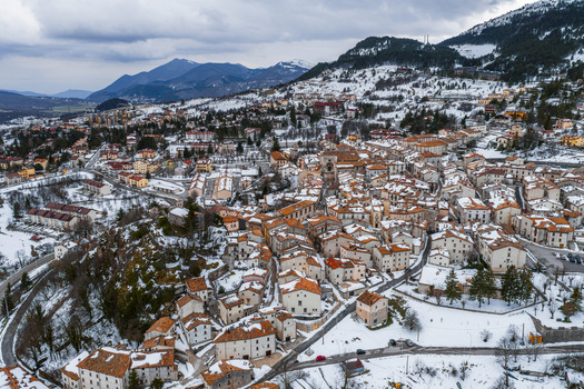 Aerial view of the historic town with snow covered terracotta rooftops and mountain scenery in Pescocostanzo Abruzzo Italy.
