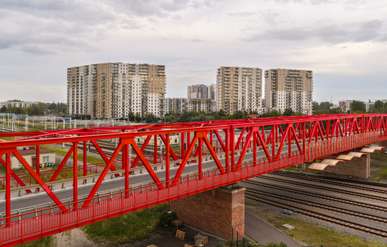 Aerial view of the historic red steel truss viaduct spanning over railway tracks with modern residential buildings in the background in Gdansk Pomeranian Voivodeship Poland. Aerial view of the historic red steel truss viaduct spanning over railway tracks with modern residential buildings in the background in Gdansk Pomeranian Voivodeship Poland.