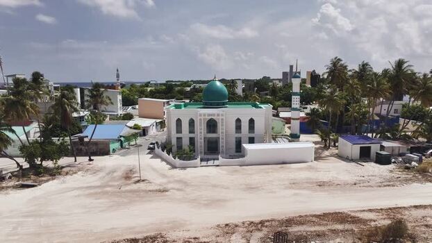 Aerial view of a white mosque with a green dome Maldives. Aerial view of a white mosque with a green dome Maldives.