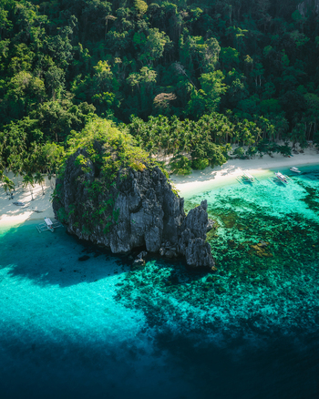 Aerial view of Papaya Beach with its iconic limestone karst formation white sand turquoise waters and lush tropical vegetation in El Nido Mimaropa Philippines. Aerial view of Papaya Beach with its iconic limestone karst formation white sand turquoise waters and lush tropical vegetation in El Nido Mimaropa Philippines.