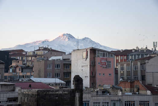 View of urban buildings and the snow capped Mount Erciyes under a clear sky in Kayseri Kayseri Turkiye. View of urban buildings and the snow capped Mount Erciyes under a clear sky in Kayseri Kayseri Turkiye.
