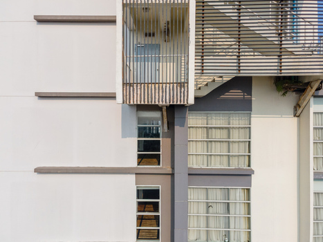 Aerial view of a modern building facade featuring a prominent balcony structure with vertical louvers clean geometric lines and large windows in Purwokerto Central Java Indonesia. Aerial view of a modern building facade featuring a prominent balcony structure with vertical louvers clean geometric lines and large windows in Purwokerto Central Java Indonesia.
