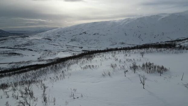 Aerial view of snowy mountains on Kvaloya island Norway.