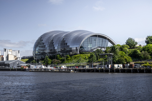 View of the Sage Gateshead music center with its distinctive curved glass and steel roof situated on the banks of the River Tyne Newcastle upon Tyne England United Kingdom. View of the Sage Gateshead music center with its distinctive curved glass and steel roof situated on the banks of the River Tyne Newcastle upon Tyne England United Kingdom.