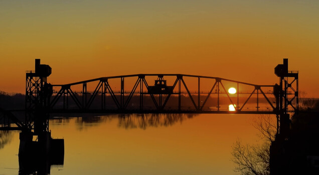 Aerial view of the Junction Bridge silhouette at sunrise over the Arkansas River in Little Rock Arkansas United States. Aerial view of the Junction Bridge silhouette at sunrise over the Arkansas River in Little Rock Arkansas United States.