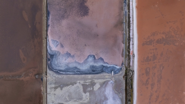 Aerial view of the vibrant pink salt pans and geometric evaporation ponds with salt crusts in Cagliari Sardinia Italy. Aerial view of the vibrant pink salt pans and geometric evaporation ponds with salt crusts in Cagliari Sardinia Italy.
