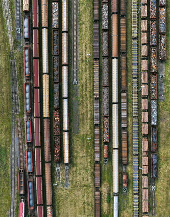 Aerial view of freight trains parked on parallel tracks in a railway yard loaded with logs and scrap metal in Saalfeld Thuringia Germany. Aerial view of freight trains parked on parallel tracks in a railway yard loaded with logs and scrap metal in Saalfeld Thuringia Germany.
