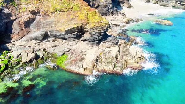 Aerial view of Lantic Bay cliffs and turquoise water United Kingdom.