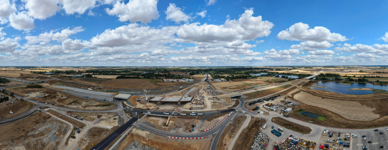 Aerial view of the Black Cat Roundabout highway construction site featuring new bridge structures heavy machinery and surrounding rural landscape in Chawston England United Kingdom. Aerial view of the Black Cat Roundabout highway construction site featuring new bridge structures heavy machinery and surrounding rural landscape in Chawston England United Kingdom.