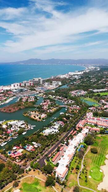 Aerial view of the sun kissed coastal city with a vibrant mix of modern buildings serene waterways and lush greenery Nuevo Vallarta Mexico.