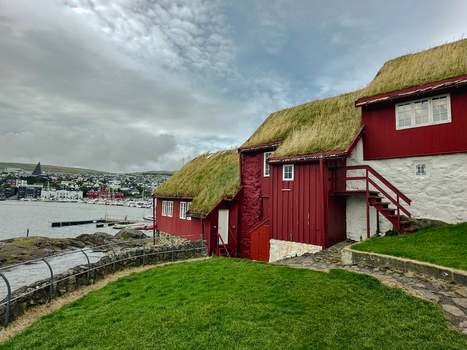 View of traditional red wooden houses with grass turf roofs overlooking the harbor in Torshavn Faroe Islands. View of traditional red wooden houses with grass turf roofs overlooking the harbor in Torshavn Faroe Islands.