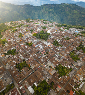 Aerial view of terracotta roofs blanketing the town nestled against the backdrop of verdant mountains a harmonious blend of urban and natural landscapes Salamina Caldas Colombia.