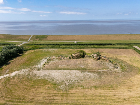 Aerial view of the Dijk van een wijf earthwork sculpture in the coastal landscape near the Wadden Sea with grassy mounds and fields in Oosterbierum Friesland Netherlands. Aerial view of the Dijk van een wijf earthwork sculpture in the coastal landscape near the Wadden Sea with grassy mounds and fields in Oosterbierum Friesland Netherlands.