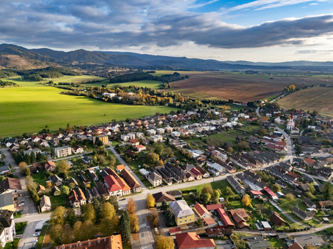 Aerial view of a charming village nestled between vibrant green fields and rich brown farmlands with distant mountains under a dramatic sky Mosovce Zilina Region Slovakia. Aerial view of a charming village nestled between vibrant green fields and rich brown farmlands with distant mountains under a dramatic sky Mosovce Zilina Region Slovakia.