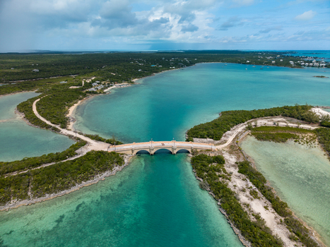 Aerial view of the stone bridge at Crab Cay connecting lush green islands over turquoise tropical waters in Exuma Exuma The Bahamas. Aerial view of the stone bridge at Crab Cay connecting lush green islands over turquoise tropical waters in Exuma Exuma The Bahamas.