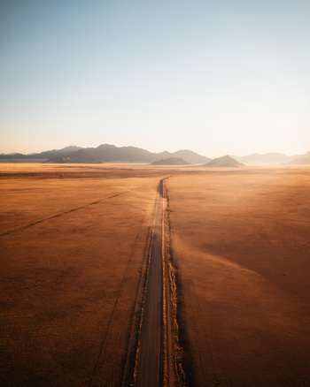 Aerial view of the D707 gravel road stretching through the vast arid desert landscape of the Karas Region Namibia.