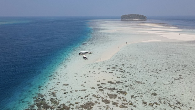 Aerial view of Raja Ampat sandbar with turquoise water coral reefs and small boats in Raja Ampat Southwest Papua Indonesia. Aerial view of Raja Ampat sandbar with turquoise water coral reefs and small boats in Raja Ampat Southwest Papua Indonesia.