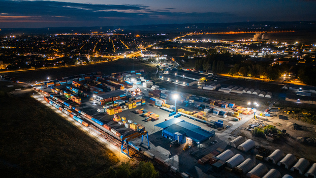 Aerial view of RTC Luka Leget logistics terminal at night with colorful shipping containers gantry cranes and illuminated storage facilities in Sremska Mitrovica Vojvodina Serbia. Aerial view of RTC Luka Leget logistics terminal at night with colorful shipping containers gantry cranes and illuminated storage facilities in Sremska Mitrovica Vojvodina Serbia.