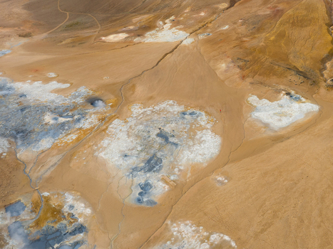 Aerial view of geothermal vents hiss amid the ochre and cream colored earth painting a surreal landscape at Hverir Reykjahl&iacute;&eth; &THORN;ingeyjarsveit Iceland.