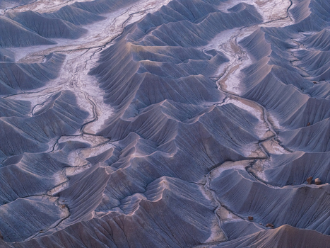 Aerial view of the intricate badlands and eroded ridges near Hanksville with dry riverbeds and soft evening light in Hanksville Utah United States.