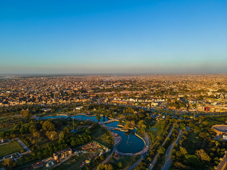 Aerial view of Minar e Pakistan surrounded by lush gardens reflecting pools and the sprawling urban landscape of Lahore Punjab Pakistan.