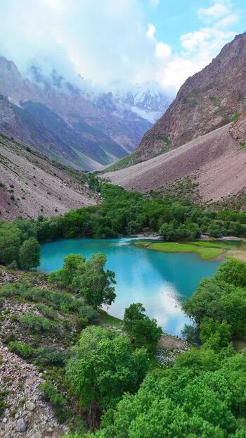 Aerial view of Qullai Vudor peak and a turquoise lake Tajikistan. Aerial view of Qullai Vudor peak and a turquoise lake Tajikistan.