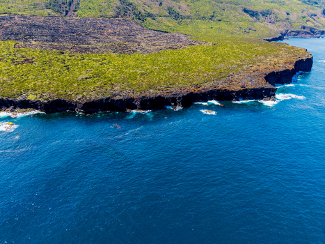 Aerial view of the rugged coastline where verdant hills meet the deep blue sea near Miradouro Prainha Pico Azores Portugal. Aerial view of the rugged coastline where verdant hills meet the deep blue sea near Miradouro Prainha Pico Azores Portugal.