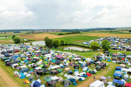 Herzogenaurach Germany 26 July 2025 Aerial view of the Open Beatz Festival camping area with hundreds of colorful tents small ponds and surrounding green fields.