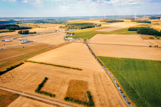 Herzogenaurach Germany 22 July 2022 Aerial view of the Open Beatz Festival site surrounded by golden fields wind turbines and a long line of cars on a sunny day. Herzogenaurach Germany 22 July 2022 Aerial view of the Open Beatz Festival site surrounded by golden fields wind turbines and a long line of cars on a sunny day.
